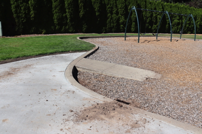 Playground on bark-chip surface with access ramp – paved access route from parking lot